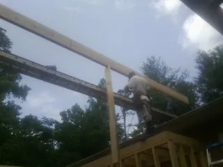 Carpenter setting a ridge beam over a new addition frame — Ice Dam Removal by Roofing Brothers in Fryeburg