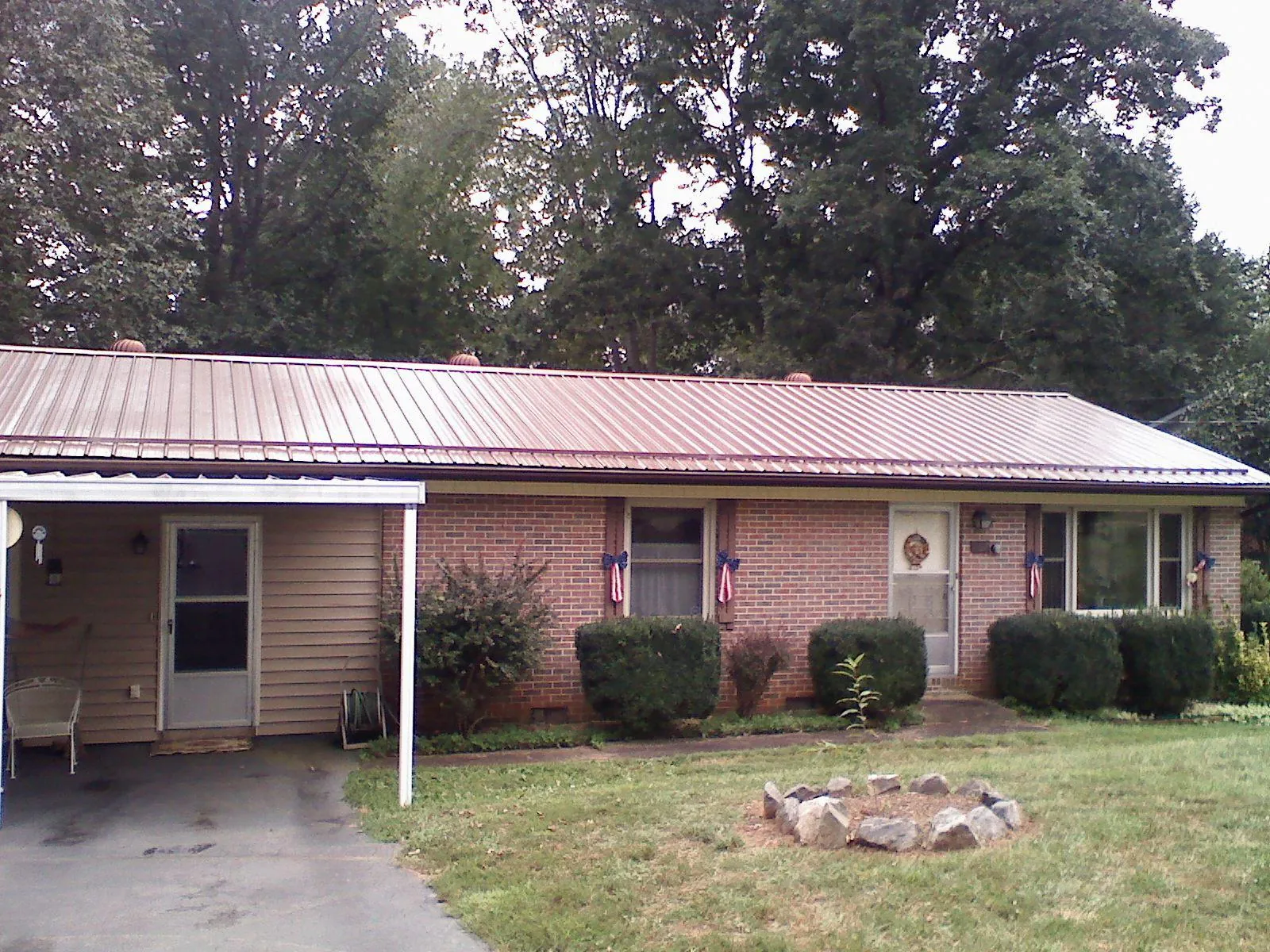 Bronze metal roof and carport on a brick ranch home — Roof Repair work by our crew in Fryeburg